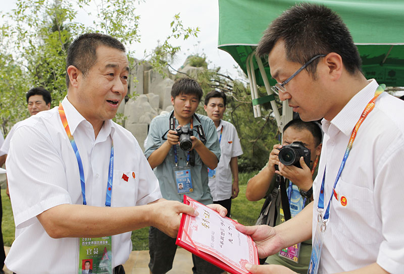 2011年7月，杨民生同志向奋战在世园会中的优秀党员颁发证书 ......